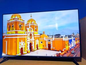 a television screen with a picture of a church at Unique garden deluxe apartment in Trujillo