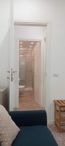a room with a blue couch and a bathroom at Cinghiale Bianco in Cagliari