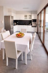 a white dining room with a table and chairs at Villa O Pomar with optional heated pool in Paul do Mar