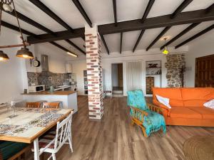 a living room with an orange couch and a kitchen at Les Coves de Lluna in Vall de Uxó