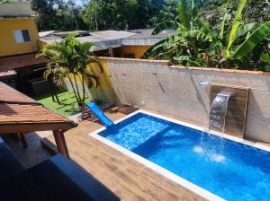 a swimming pool with a water slide in a backyard at Loft completo com HIDRO e piscina próx à praia in Caraguatatuba