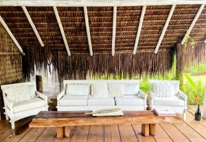 a living room with two white couches and a table at Caiçara Bangalôs Barra Grande Maraú-BA in Barra Grande +58 photos