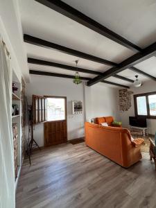 a living room with an orange couch in a room at Les Coves de Lluna in Vall de Uxó