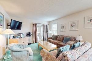 a living room with a couch and a table at Virginia Dare Escape in Kill Devil Hills