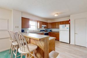 a kitchen with wooden cabinets and a white refrigerator at Virginia Dare Escape in Kill Devil Hills