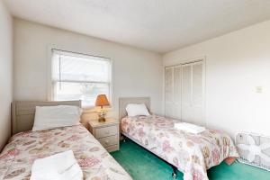 a bedroom with two beds and a window at Virginia Dare Escape in Kill Devil Hills