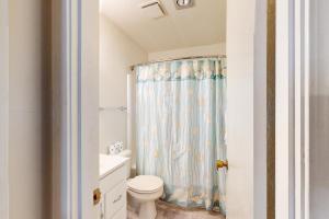 a bathroom with a toilet and a shower curtain at Virginia Dare Escape in Kill Devil Hills +14 photos