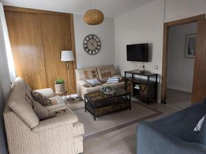 a living room with two couches and a tv at La Fuentona in Celorio