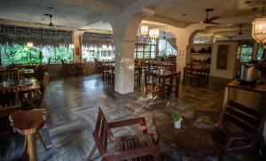 an empty restaurant with wooden tables and chairs at Villas Ecotucan in Bacalar