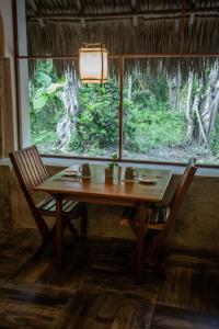 a wooden table and two chairs in a room with a window at Villas Ecotucan in Bacalar +36 photos