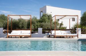 a swimming pool with white chairs and a swimming at Finca las Calmas Adults Only Boutique Retreat & Dining Experience in Moraleda de Zafayona