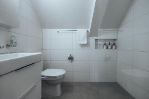 a white bathroom with a toilet and a sink at LaVida LakeSoul Cozy Retreat in Murten am See & Altstadt, free parking in Murten +44 photos