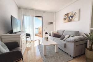 a living room with a couch and a tv at Panoramic Sea View Cabo Roig in Orihuela Costa
