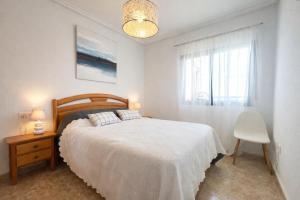 a white bedroom with a bed and a window at Panoramic Sea View Cabo Roig in Orihuela Costa