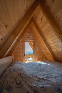a room with a bed in a attic with a window at Apartmani Perosevic in Danilovgrad