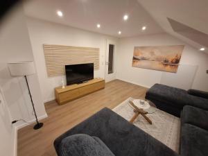 a living room with a couch and a flat screen tv at Ferienwohnung Elisabeth 2 Waxweiler in Waxweiler