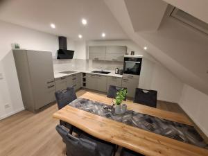 a kitchen and dining room with a wooden table and chairs at Ferienwohnung Elisabeth 2 Waxweiler in Waxweiler