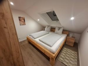 a small bedroom with a bed in a attic at Ferienwohnung Elisabeth 2 Waxweiler in Waxweiler +4 photos
