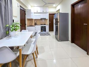a kitchen with a table and chairs and a refrigerator at Sunny Canopy in Hulhumale