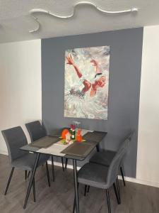 a dining room table with chairs and a painting on the wall at Seehaas1 in Friedrichshafen