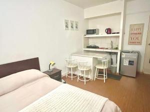 a bedroom with a bed and a kitchen with stools at Lima Mini Aparts Monterrico - Cerca Embajada EEUU in Lima
