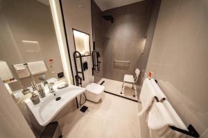 Aurion Al-Aqeeq Hotel في المدينة المنورة: حمام أبيض اللون مزود بحوض غسيل ومرحاض +31 صورة
