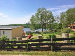 a fence in front of a house and a lake at Bungalow in Klein Labenz for 4 Personen in Klein Labenz +3 photos