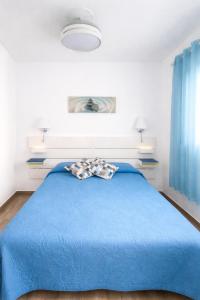 a bedroom with a blue bed with a blue blanket at Casa Ángela in La Restinga
