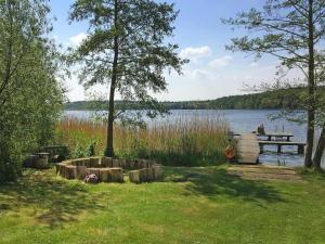 a person sitting at a picnic table next to a lake at Bungalow in Klein Labenz for 4 Personen in Klein Labenz