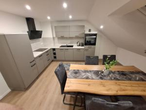 a kitchen and dining room with a wooden table and chairs at Ferienwohnung Elisabeth 2 Waxweiler in Waxweiler