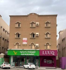 a tall building with cars parked in front of it at سويتات مفروشة 2 in Al Hofuf