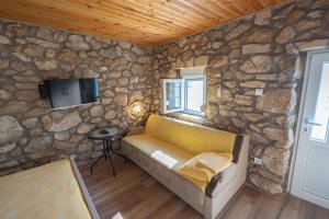 a living room with a stone wall with a couch at Apartmani Perosevic in Danilovgrad