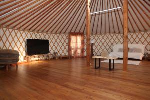 a room with a tent with a bed and a tv at Jurta Les Park in Vřesovice