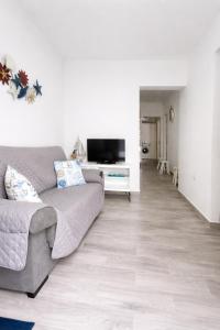 a living room with a couch and a television at Casa Ángela in La Restinga