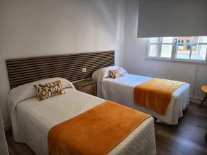 a hotel room with two beds and a window at Apartamentos Demar Luis Casais in O Grove