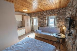 a living room with a couch and a stone wall at Apartmani Perosevic in Danilovgrad