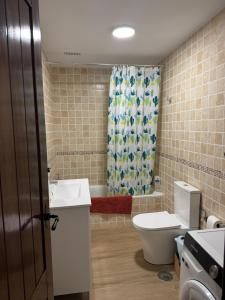 a bathroom with a toilet and a sink and a shower curtain at Arroyo Alpujarra in Guarros +5 photos
