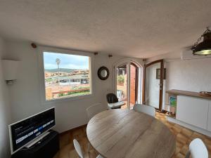 a dining room with a wooden table and a large window at Casa Vacanza con Piscina e Accesso diretto al Mare in Santa Marinella