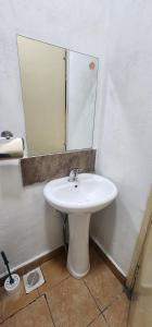a bathroom with a white sink and a mirror at Emeli apartments in Nairobi