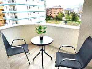 a table and chairs on a balcony with a window at Apartamente Victory Luxury Eforie Nord in Eforie Nord