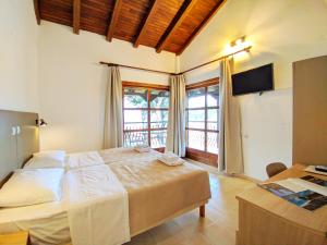 a bedroom with a large bed and a large window at Villa Anna Maria in Agia Paraskevi