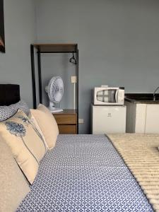 a bedroom with a bed and a microwave at Hospedagem Central Curitiba - Quartos Confortáveis no Centro in Curitiba +69 photos