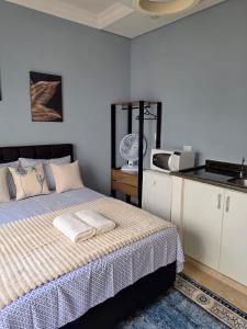 a bedroom with a bed with two towels on it at Hospedagem Central Curitiba - Quartos Confortáveis no Centro in Curitiba