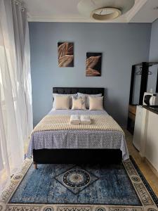 a bedroom with a large bed with a blue wall at Hospedagem Central Curitiba - Quartos Confortáveis no Centro in Curitiba