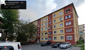 a large building with cars parked in a parking lot at Casa Rusu -Moroasa-Self check in-24h Netflix in Reşiţa