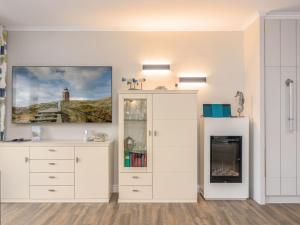 a room with a white cabinet and a fireplace at See Lün 4 Sterne TOP-Fewo in Westerland Sylt strandnah zentral mit Balkon Sauna in Westerland