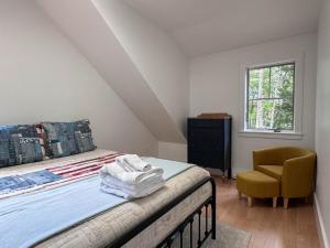 a bedroom with a bed and a chair and a window at Long Lake-Lake Front - in Bridgton