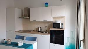 a kitchen with white cabinets and a microwave at Casa PERLAMARE in Otranto +39 photos