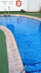 a swimming pool with blue water in front of a building at Arroyo Alpujarra in Guarros