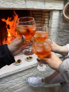 a group of people holding wine glasses in front of a fire at "Villa 70" Guesthouse in Gjirokastër